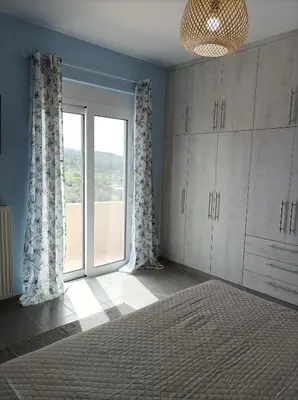 a bedroom with a bed and a large window at Annas House Theologos in Theologos