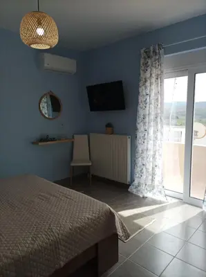 a bedroom with a bed and a sliding glass door at Annas House Theologos in Theologos