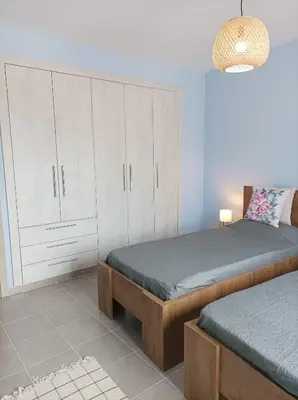 a bedroom with two beds and a white cabinet at Annas House Theologos in Theologos