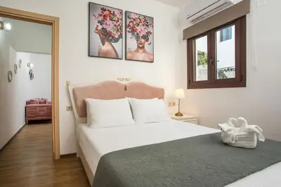 a bedroom with a large white bed and a window at Bliss Luxury Suites in Líndos