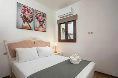 a bedroom with a white bed and three pictures on the wall at Bliss Luxury Suites in Líndos