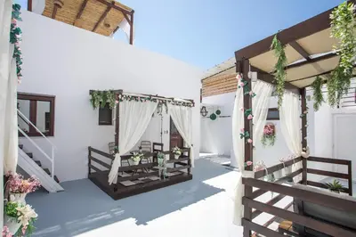 a white house with a porch with a swing at Bliss Luxury Suites in Líndos