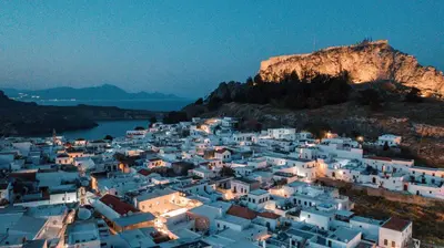 a group of white buildings on a hill at night at Bliss Luxury Suites in Líndos