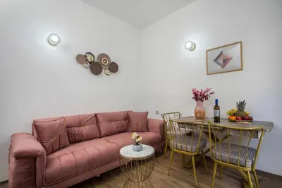 a living room with a pink couch and a table at Bliss Luxury Suites in Líndos