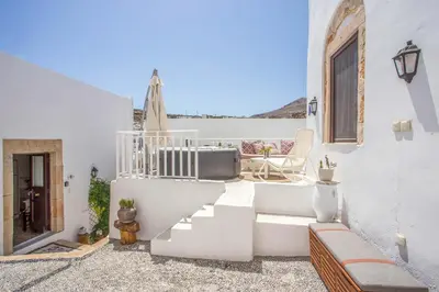 a white house with white stairs and a patio at Heritage Luxury Suites in Líndos