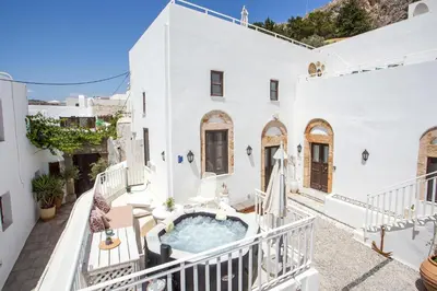 an outdoor hot tub in the middle of a white house at Heritage Luxury Suites in Líndos