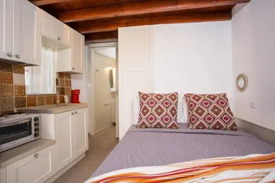 a small bedroom with a bed and a microwave at Heritage Luxury Suites in Líndos