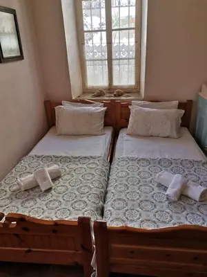 two twin beds in a room with a window at GIANNAS HOUSE in Symi