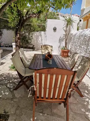 a wooden table and chairs sitting on a patio at GIANNAS HOUSE in Symi