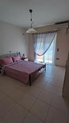 a bedroom with a large bed and a large window at Villa Katerina in Ialyssos