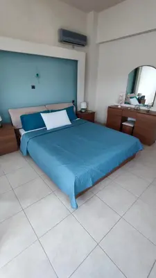 a large blue bed in a room with a mirror at Villa Katerina in Ialyssos