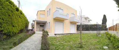 a yellow and white house with a grass yard at Villa Katerina in Ialyssos