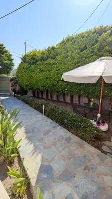 a patio with an umbrella and a table and chairs at Villa Katerina in Ialyssos