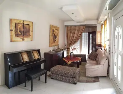 a living room with a piano and a couch at Villa Katerina in Ialyssos