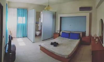 a bedroom with a large bed with blue pillows at Villa Katerina in Ialyssos