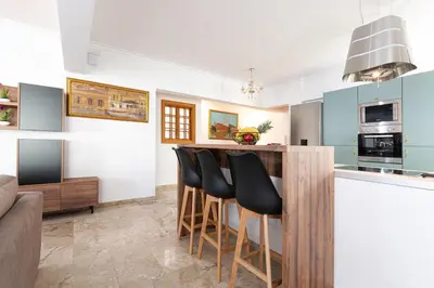 a kitchen with a bar with black chairs in it at Casa di Flora Luxurious Apartment in Rhodes in Rhodes Town