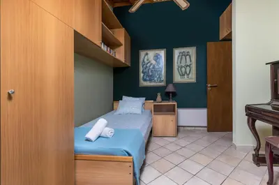 a small bedroom with a bed and a desk at Villa René in Koskinou