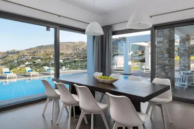a dining room with a table and chairs and a pool at Alindo Villa I in Líndos