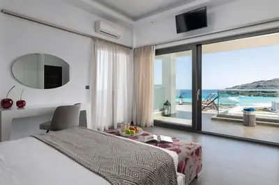 a bedroom with a bed and a view of the ocean at Alindo Villa I in Líndos