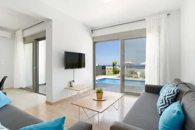 a living room with a couch and a tv at Villa Rhodes Sea View by Villa Plus in Ixia