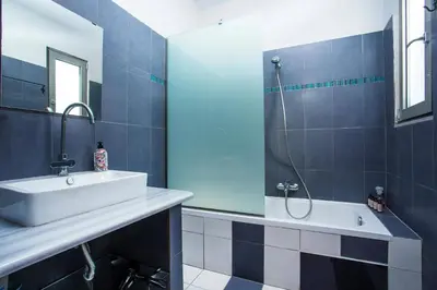 a blue tiled bathroom with a sink and a shower at Villa Rhodes Sea View by Villa Plus in Ixia