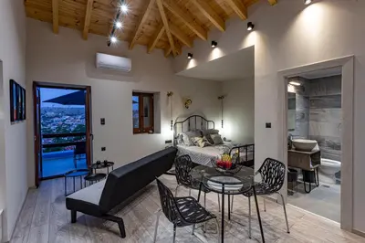 a living room with a bed and a table and chairs at Althea Apartments 1 in Halki
