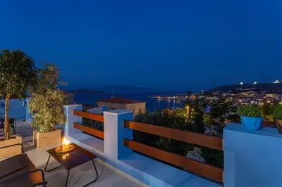 a balcony with a view of the city at night at Althea Apartments 1 in Halki