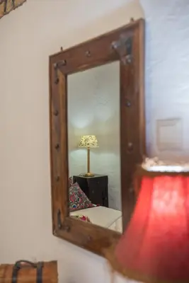 a mirror on a wall with a lamp in a room at Philoxenia traditional house in Pastida