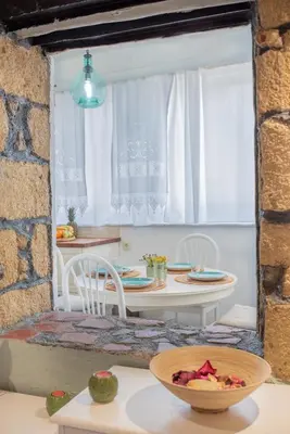 a kitchen with a table and chairs and a window at Philoxenia traditional house in Pastida