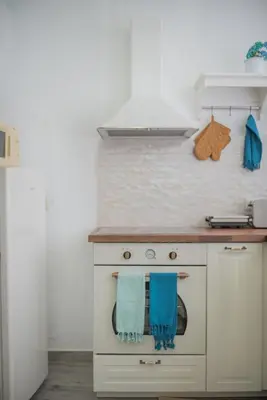 a kitchen with a stove with blue towels on it at Philoxenia traditional house in Pastida