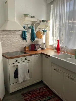 a white kitchen with a sink and a stove at Philoxenia traditional house in Pastida