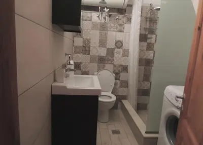 a small bathroom with a toilet and a sink at Aloustina's House in Symi
