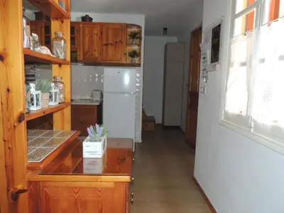 a kitchen with wooden cabinets and a white refrigerator at Aloustina's House in Symi