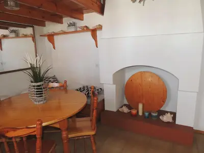 a dining room with a table and a fireplace at Aloustina's House in Symi