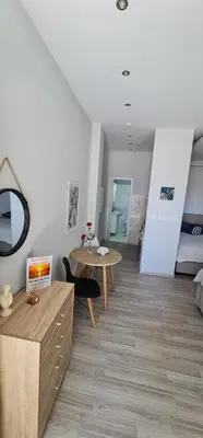a living room with a table and a room with a bed at Sea & Sun cozy studio in Kremasti