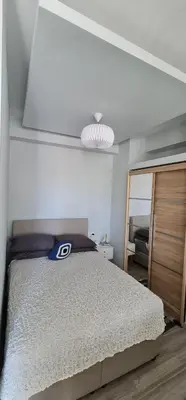 a white bedroom with a bed and a mirror at Sea & Sun cozy studio in Kremasti