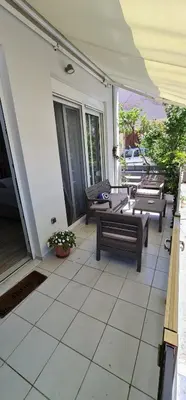 a patio with benches and tables on a house at Sea & Sun cozy studio in Kremasti