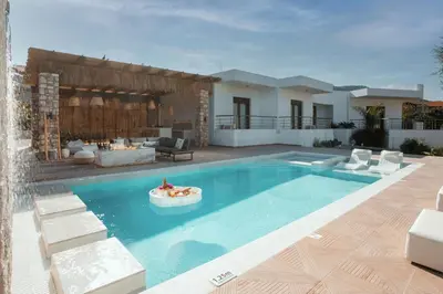 a swimming pool in a backyard with a house at Le Ialyse Luxury Villa in Ialyssos