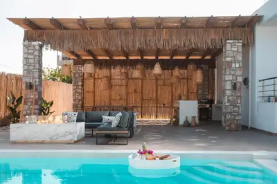 a patio with a pool and a wooden pergola at Le Ialyse Luxury Villa in Ialyssos