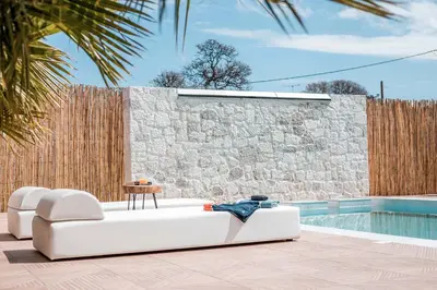 a white couch sitting on a patio next to a pool at Le Ialyse Luxury Villa in Ialyssos
