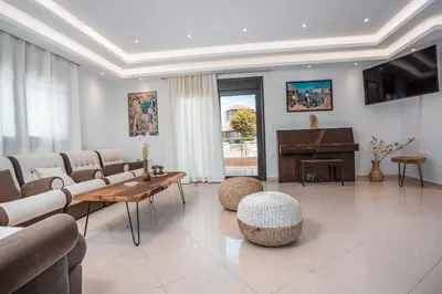 a living room with a couch and a piano at Le Ialyse Luxury Villa in Ialyssos