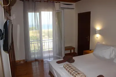 a bedroom with a bed and a window with a balcony at K Farm House in Kalavárda
