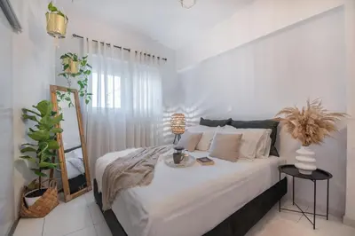 a bedroom with a bed with a mirror and a lamp at Inconceptual apartment in Paradeísion