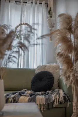 a pillow sitting on a couch in front of a window at Inconceptual apartment in Paradeísion
