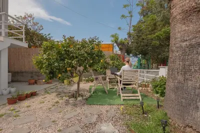a woman sitting at a table in a garden at Inconceptual apartment in Paradeísion