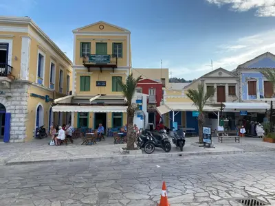 a group of people sitting outside of a building at Green Symi Apartment in Symi