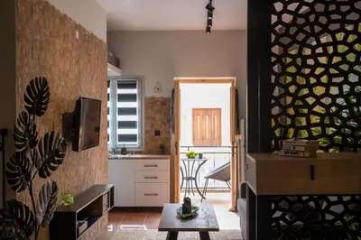 a kitchen and living room with a table in a room at Green Symi Apartment in Symi