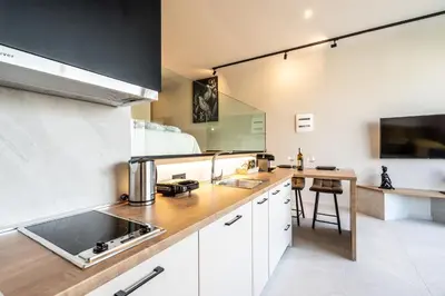a kitchen with white cabinets and a wooden counter top at Pathos SeaSide Suites in Faliraki