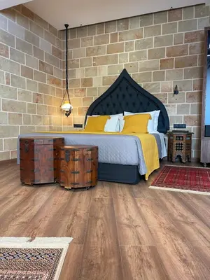 a bedroom with a bed and a brick wall at Utopia Luxury Suites - Old Town in Rhodes Town