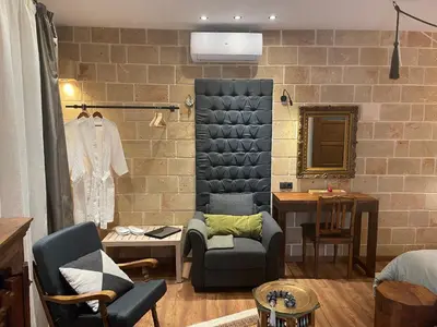 a living room with a couch and a chair at Utopia Luxury Suites - Old Town in Rhodes Town